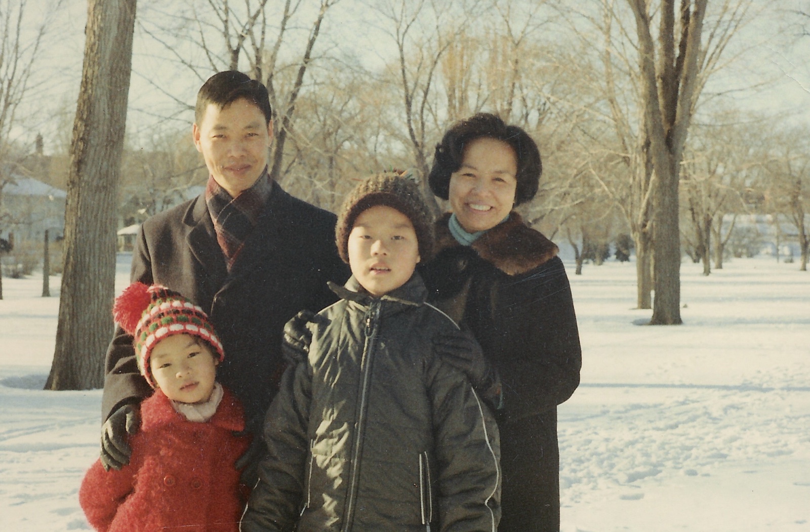 The Chang family standing in the snow in front of trees, December 1967
