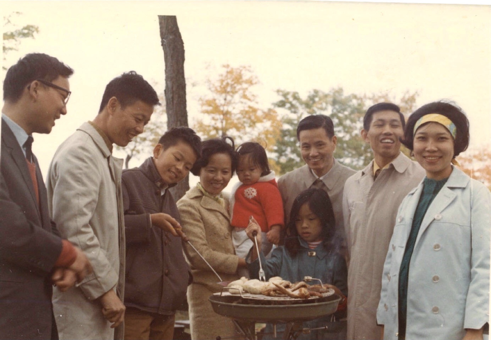 A group standing around a grill with food, Algonquin Park, 1970
